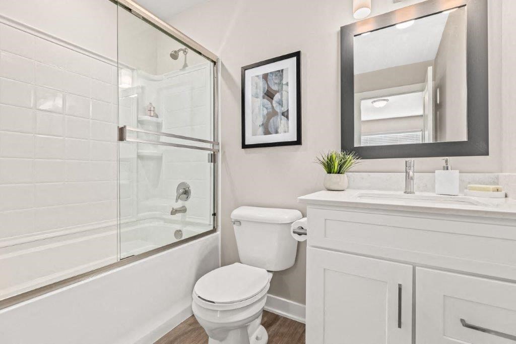 a white bathroom with a shower toilet and sink