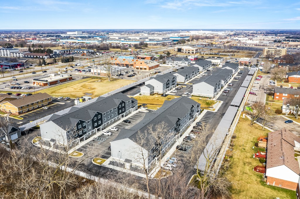 A large parking lot with several buildings in the background.