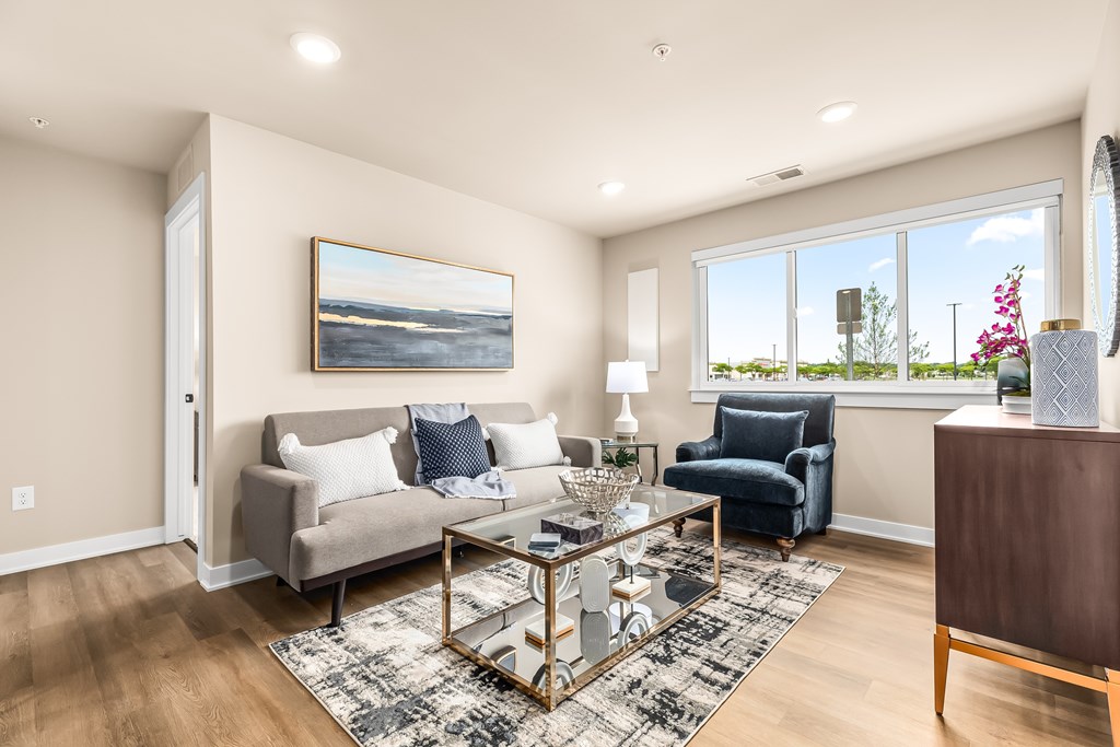 A living room with a couch, chair, and a painting on the wall.
