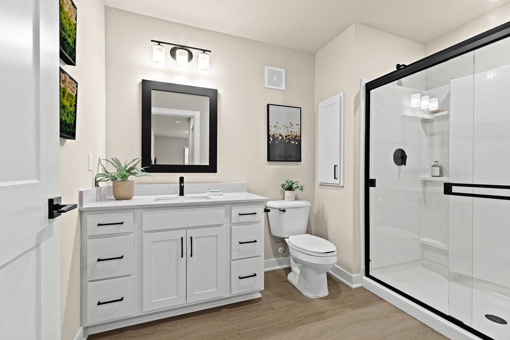 A white bathroom with a sink, toilet, and mirror.