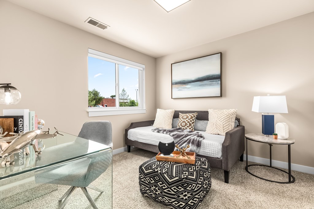 A living room with a glass table and a grey chair.