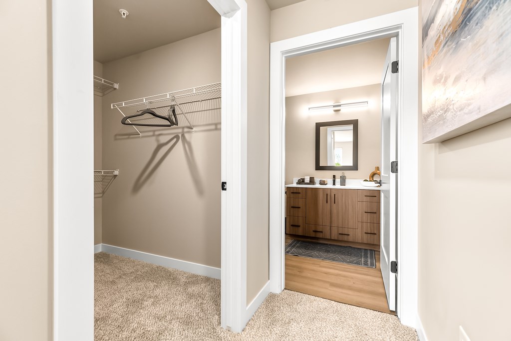 A room with a mirror and a wooden cabinet.