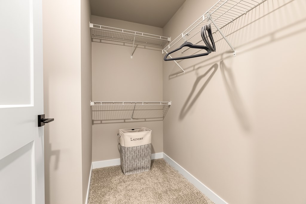A laundry room with a white door, a white basket, and a white wall.