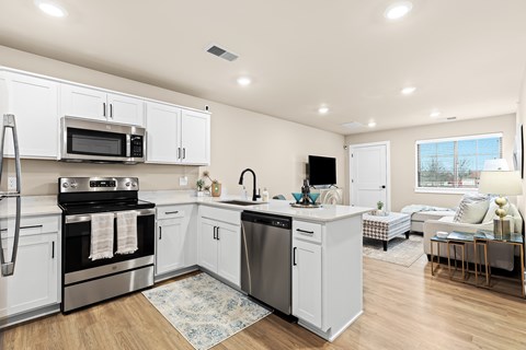 A modern kitchen with white cabinets and stainless steel appliances.