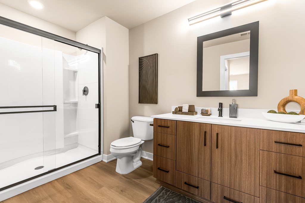A modern bathroom with a toilet, sink, and shower.