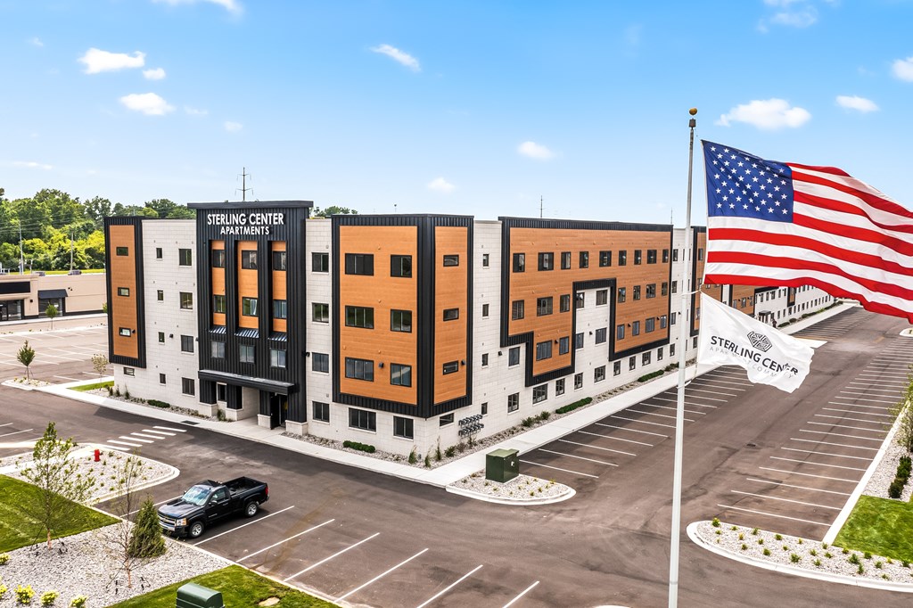 Sterling Center parking lot with a black truck and a large American flag.