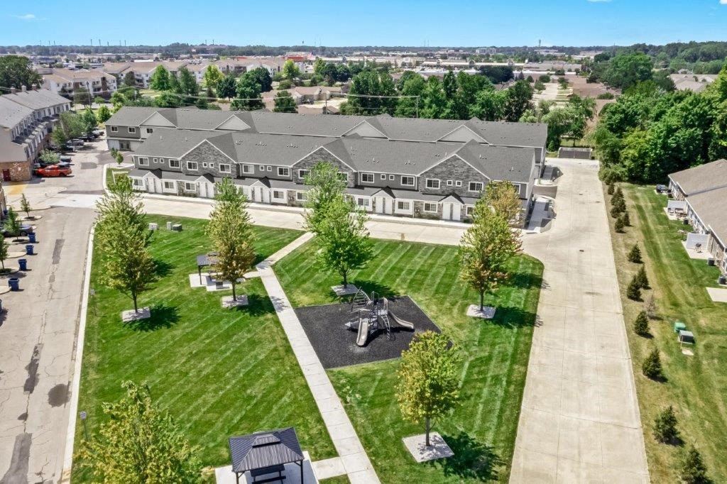 an aerial view of a building with a fountain in the middle of a park