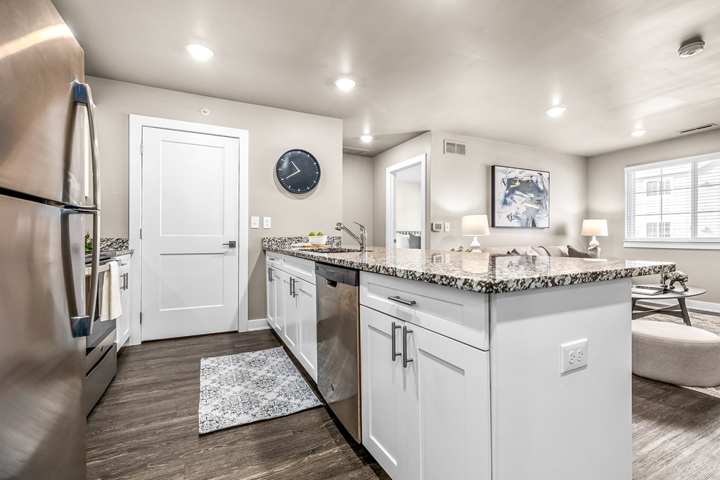 A kitchen with white cabinets and a granite countertop.