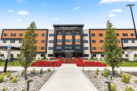 a large building with a sidewalk and trees in front of it