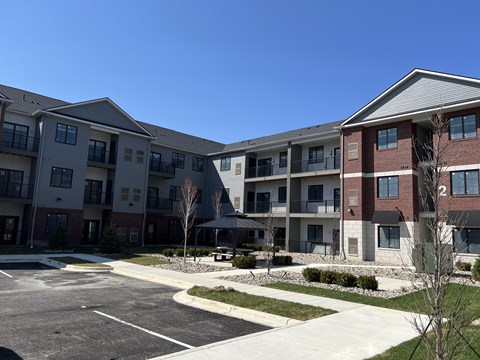 Apartment complex with a parking lot in front.