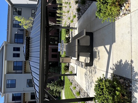 A modern building with a grey facade and a green lawn in front.