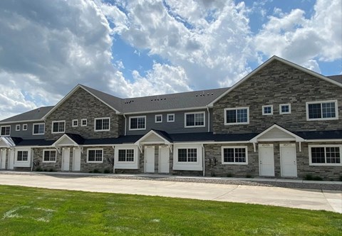 a large brick house with white doors and a blue roof