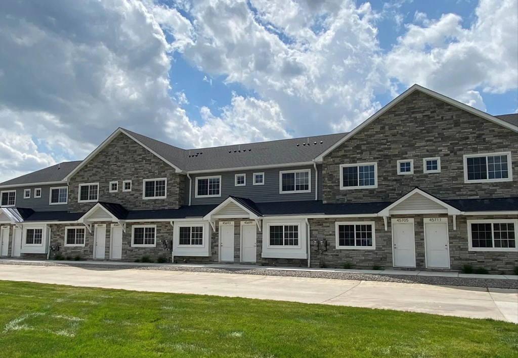 a large brick house with white doors and a blue roof