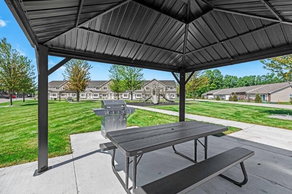 a picnic area with a table and a grill