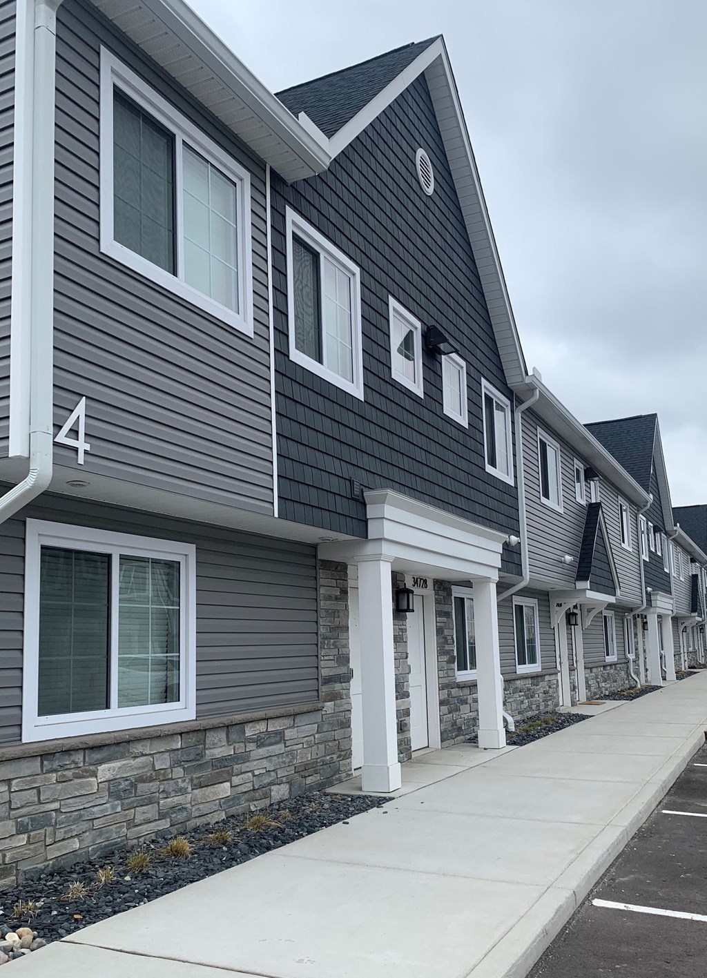 a gray house with gray siding and a sidewalk