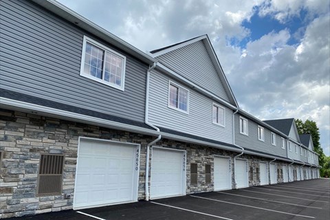 a gray brick building with two white garage doors