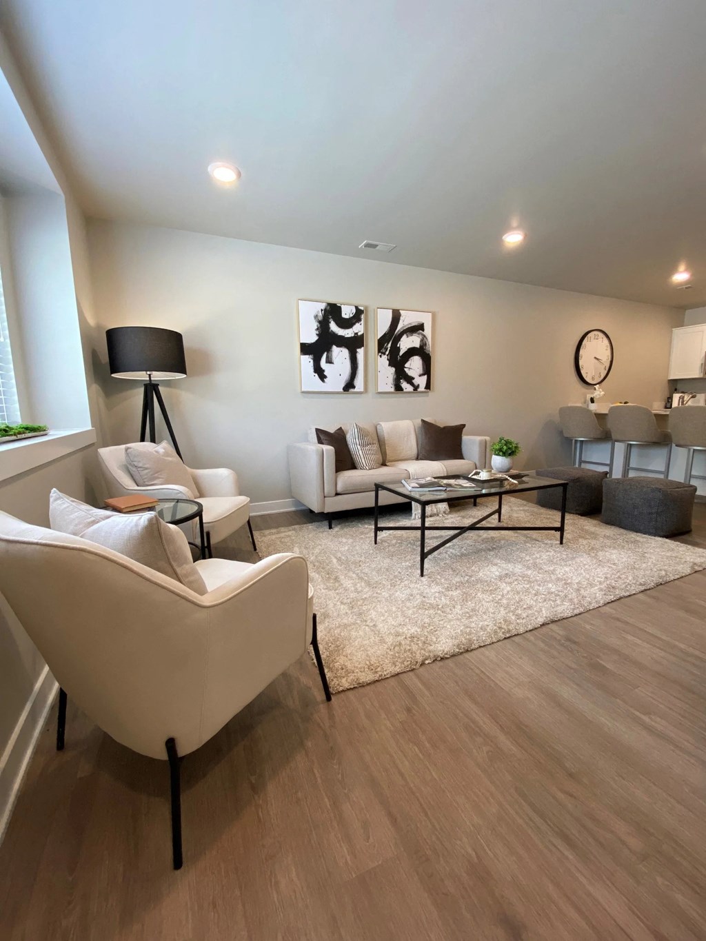 a living room with white furniture and a rug
