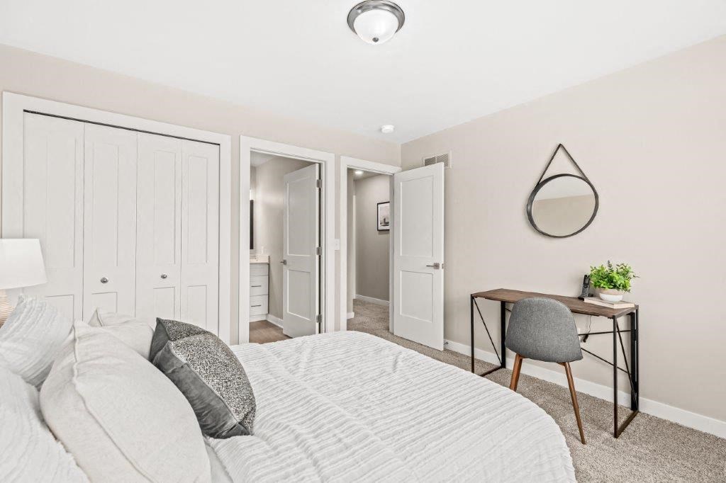 a bedroom with a bed and a desk with a mirror