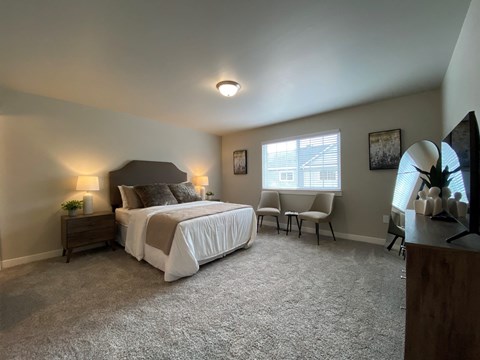 a bedroom with a bed and a desk and a window