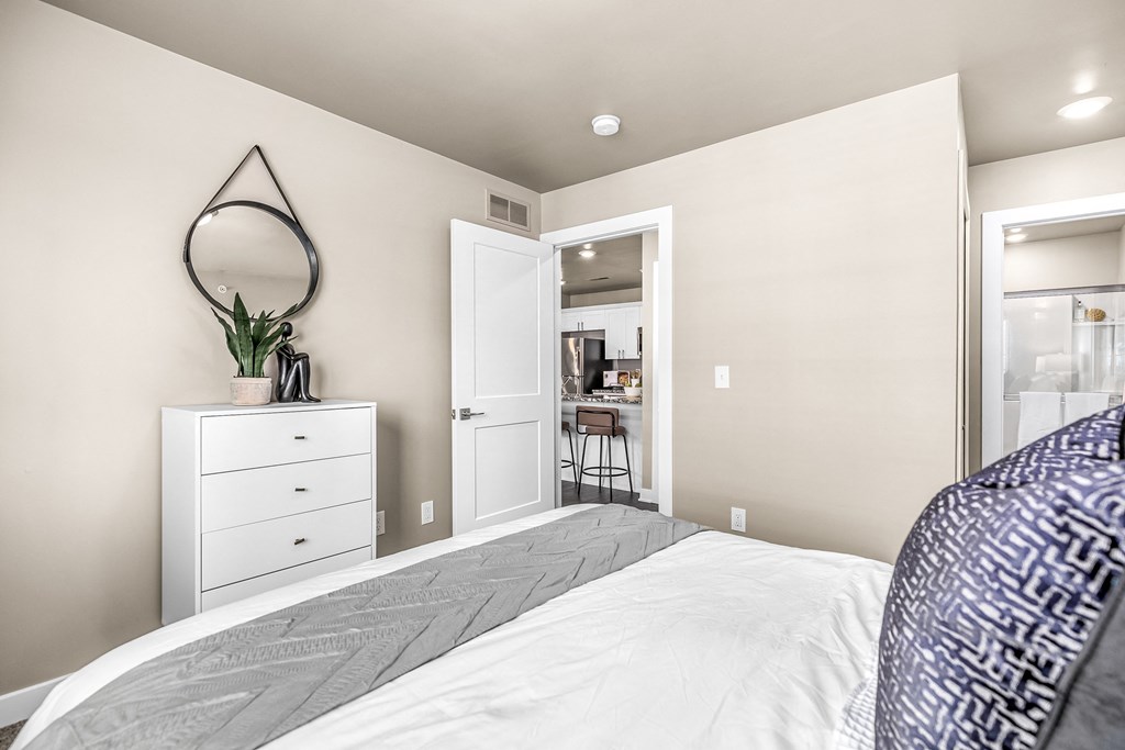 A bedroom with a bed, dresser, and mirror.