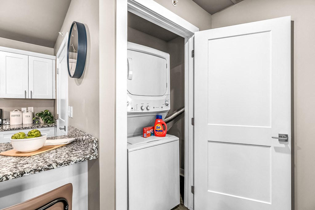 the private laundry room of a model home with a washer and dryer