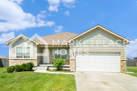 a house with a white garage door and a lawn