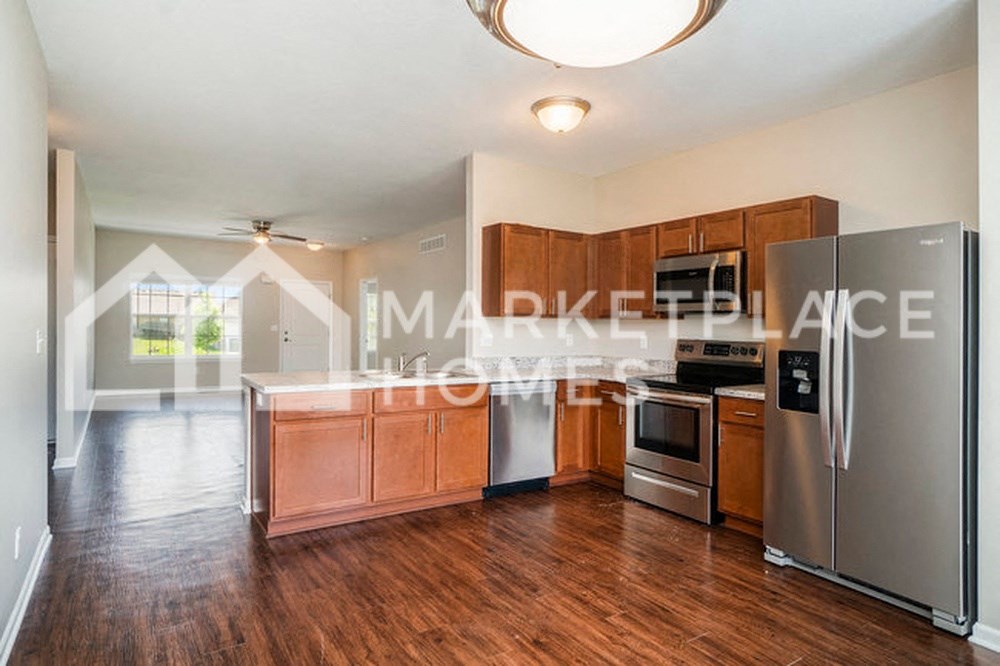a kitchen with wood floors and stainless steel appliances