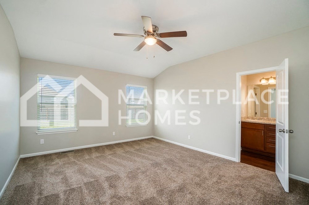 an empty living room with a ceiling fan