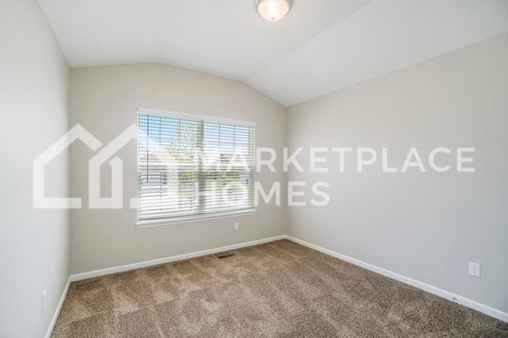 an empty living room with carpet and a window