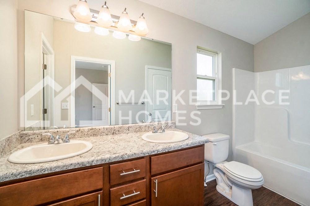a bathroom with two sinks and a toilet