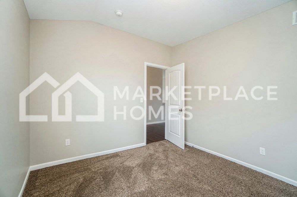 a bedroom with carpet and a white door