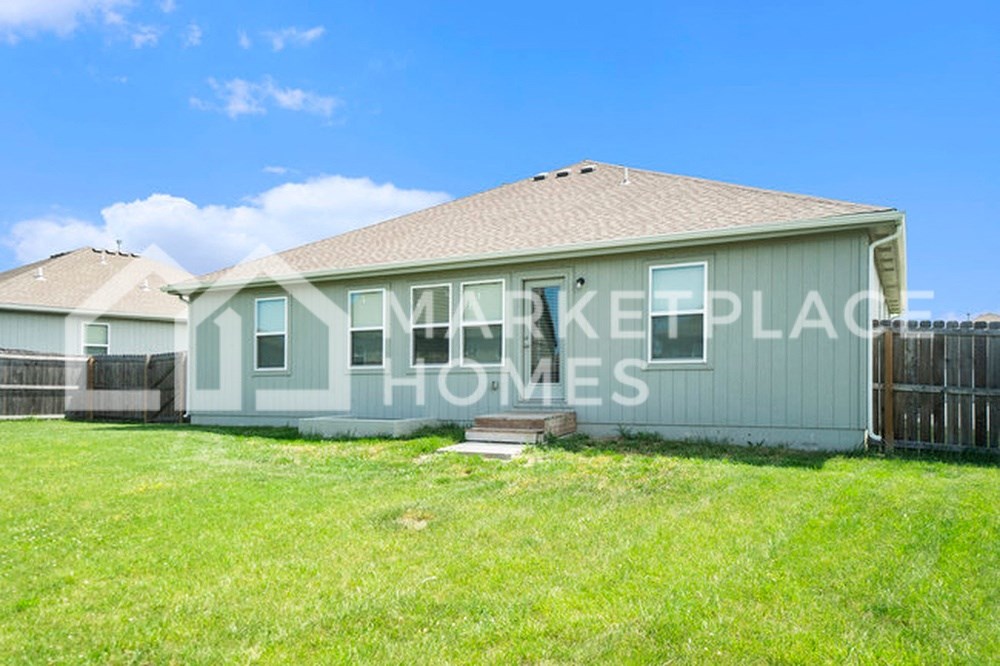 a green house with a yard in front of it