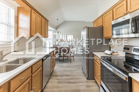 A modern kitchen with wooden cabinets and stainless steel appliances.