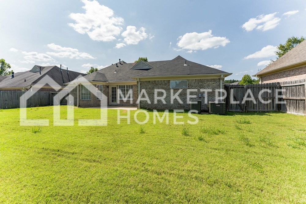 a large yard with a house and a fence