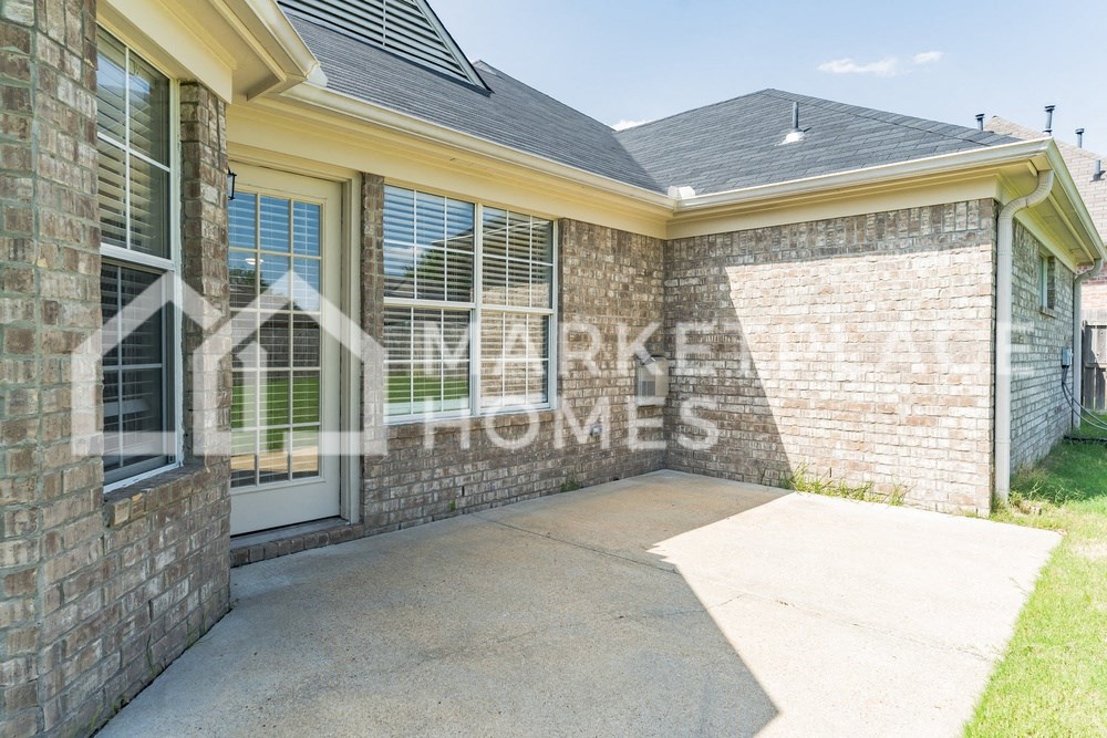 a patio in front of a brick house