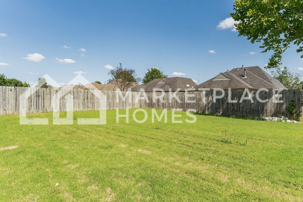 a backyard with a yard and a fence