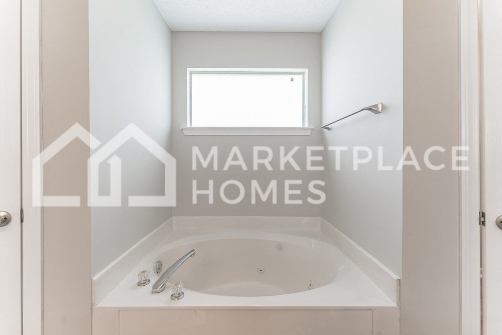 a bathroom with a bath tub and a window