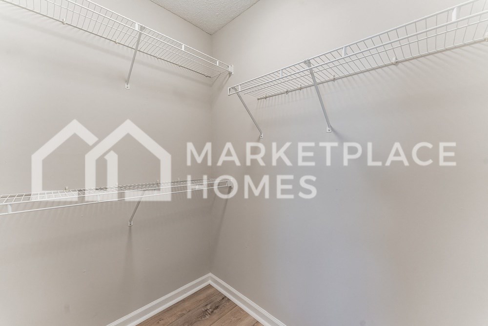 two closets in a room with the marketplace homes logo on the wall