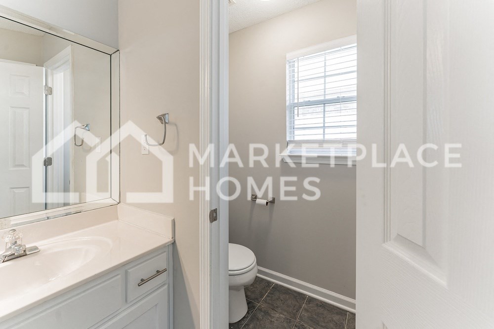 a bathroom with a toilet and a sink and a mirror