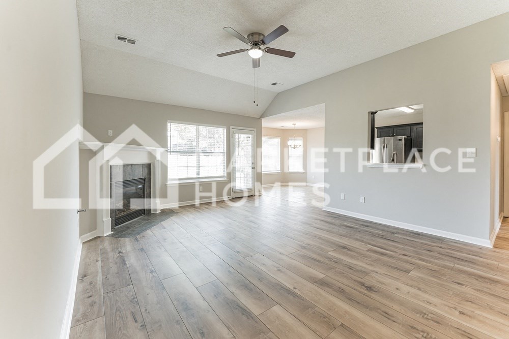 a large living room with a fireplace and hardwood floors