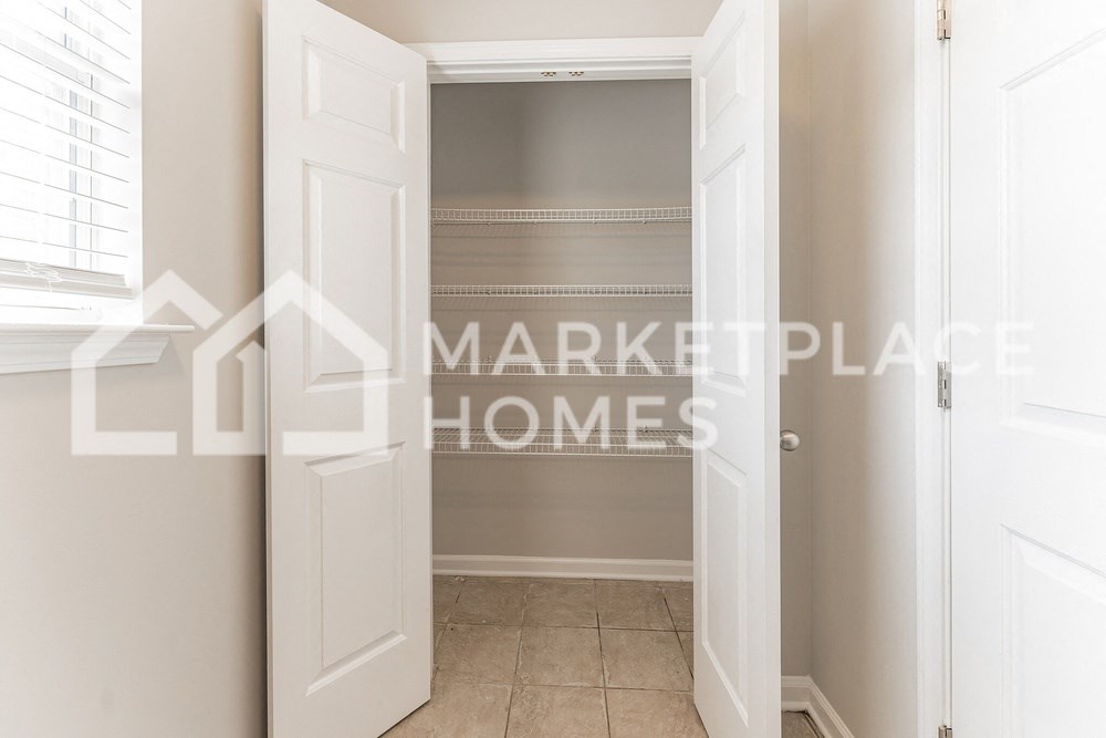 a walk in closet in a home with a white door