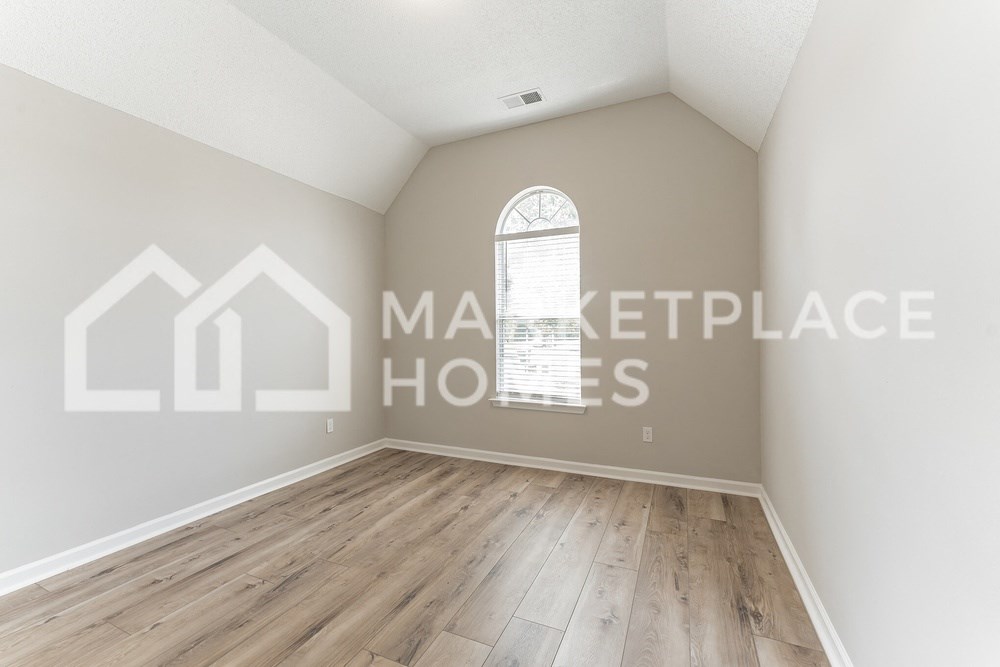 an empty room with hardwood floors and a large window