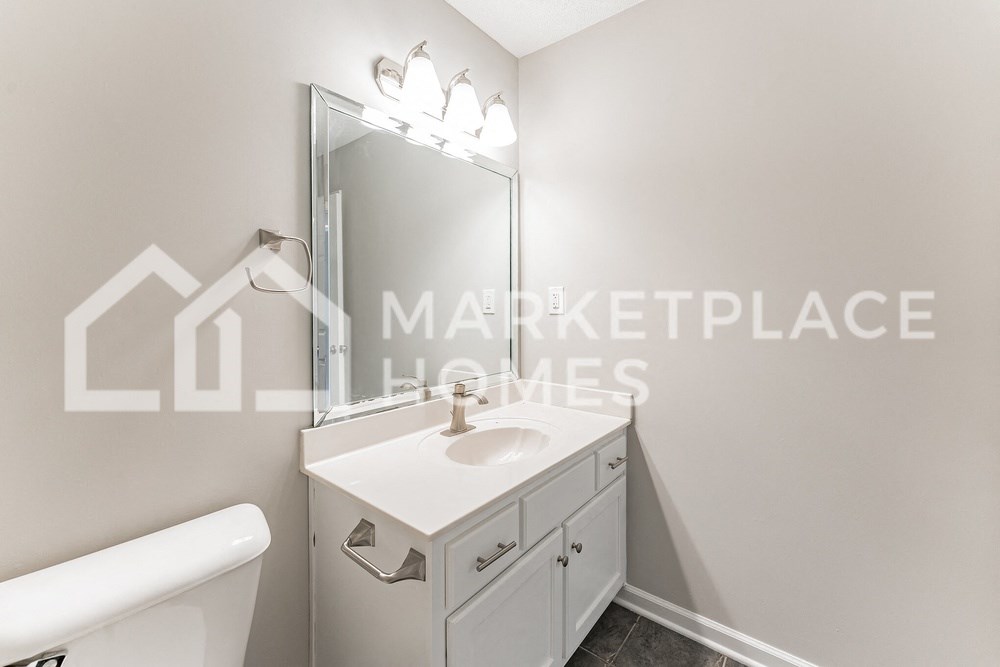 a renovated bathroom with a white sink and toilet and a mirror