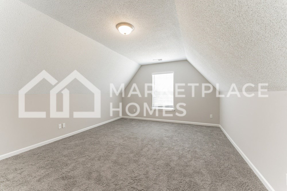 an empty room with carpet and a window