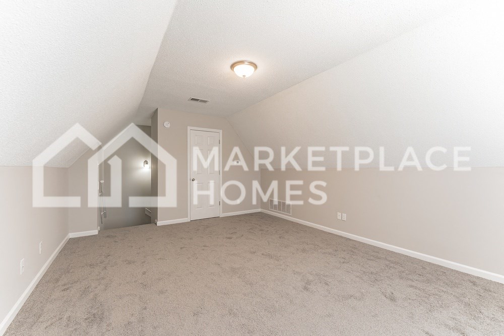 an empty bedroom with carpet and a door to the market