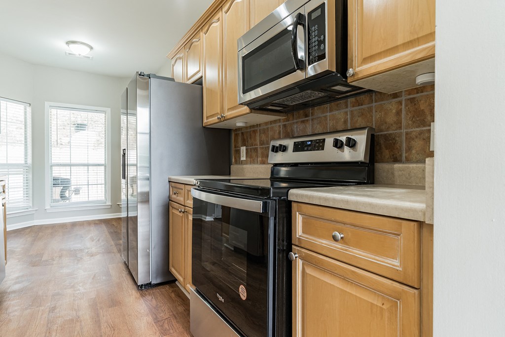 a kitchen with stainless steel appliances and wooden cabinets