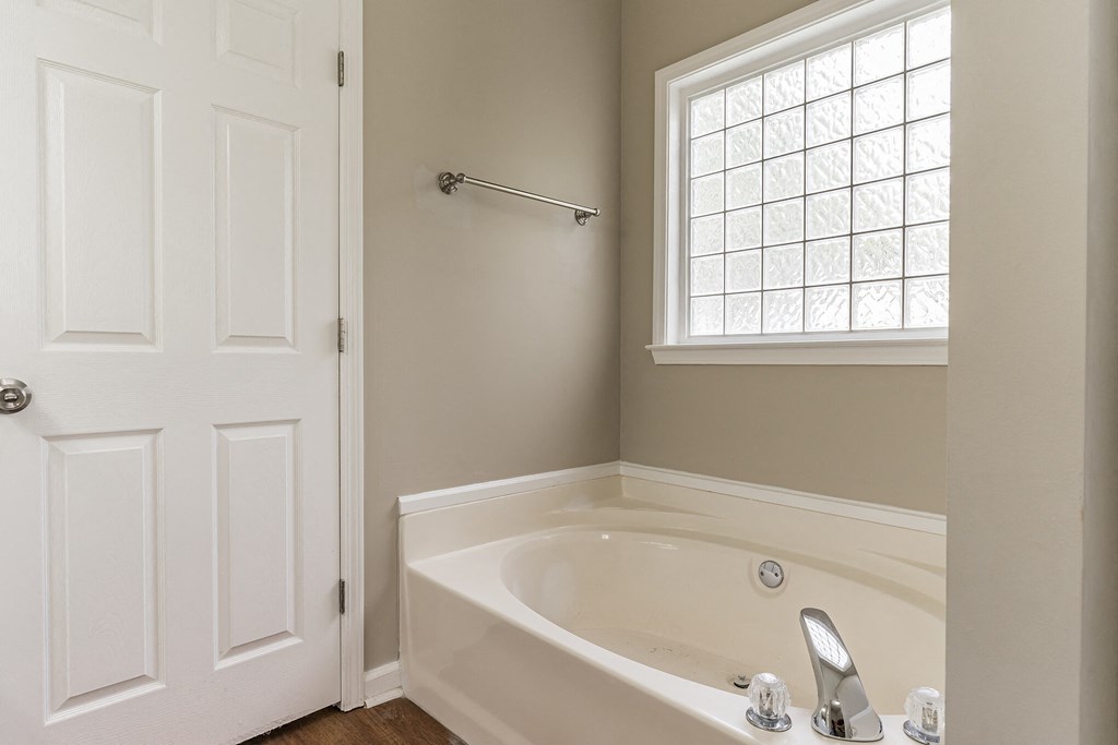 an empty bathroom with a bath tub and a window