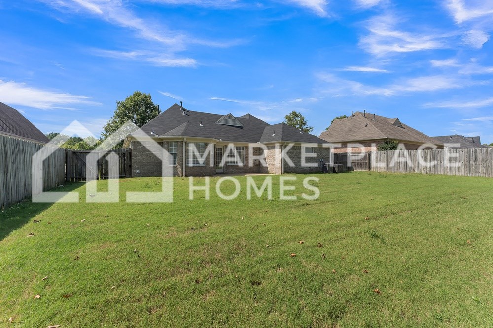 a large yard with a fence and a house