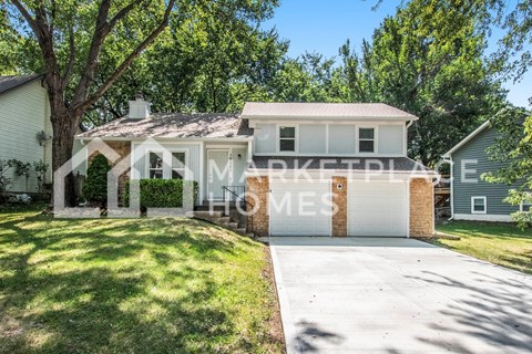 a small house with a driveway and a garage door