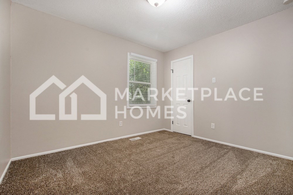 a bedroom with a carpeted floor and a white door